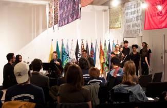 New Voices Literary Festival performance amidst Aram Han Sifuentes' Spring 2019 exhibition, Protest Banner Lending Library.