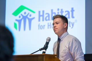 A student presenting his work for Habitat for Humanity