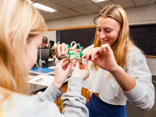 2 students using a chemistry model