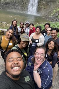 Group of people posing in front of a waterfall