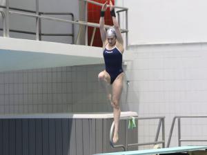 A woman jumps from a diving board
