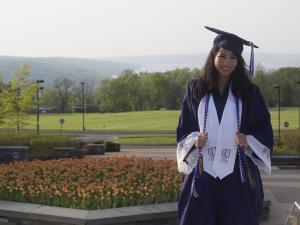 A young woman wearing graduation robes and a mortarboard