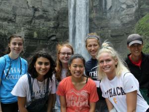 A group of young people in front of a waterfall