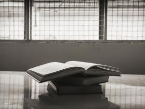 Books on a table in front of prison windows