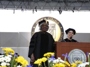 Two women on stage in academic regalia