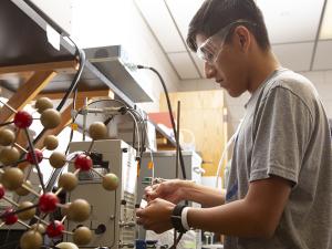 student works with scientific equipment in a lab