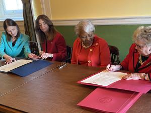 women in government signing official document