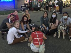 A group of IC students sitting outside with a dog