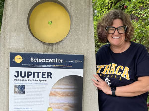 Photo of a woman standing by a Jupiter sign.