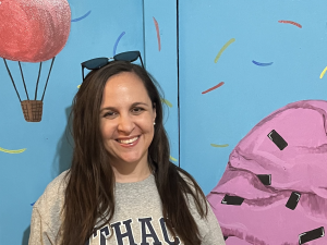 Photo of a woman standing by an ice cream mural.