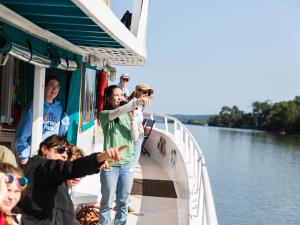 An educator on a boat teaches families. 