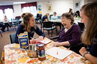 student working with resident at assisted living facility