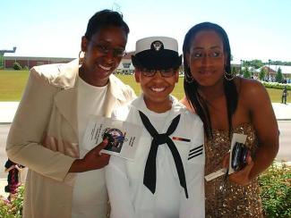 A family photo of three women. The woman in the middle wears a US Navy uniform. 