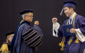 Student fist-bumping president Cornish