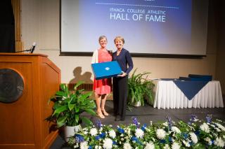 Susan Bassett presenting Paula Miller with her IC Athletic Hall of Fame plaque in 2014.