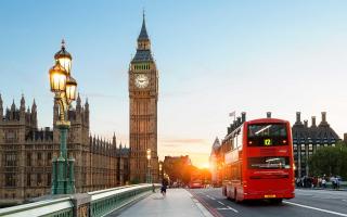 An iconic shot of London, showing Parliament, Big Ben, and a red double-decker bus.