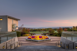 View across the Ithaca College campus to Cayuga Lake and distant hills, at dusk.