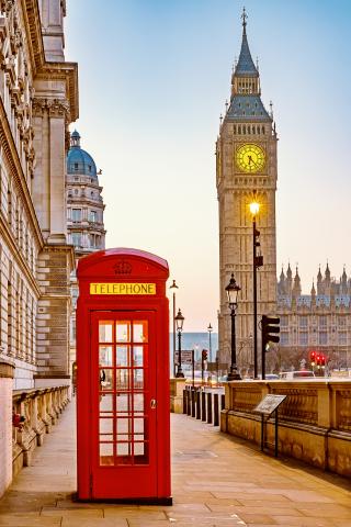 A street view in London, showing a red phone box in the foreground and Big Ben in the background.