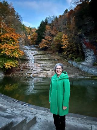 Dr. Meghan Callahan, Director of the Ithaca College London Center, standing in front of Buttermilk Falls in Ithaca, NY.