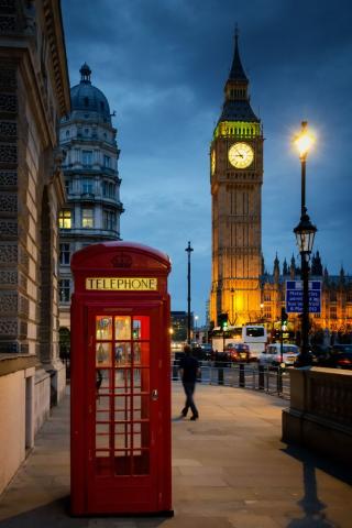 A street view in London, showing an iconic red phone booth and Big Ben in the background