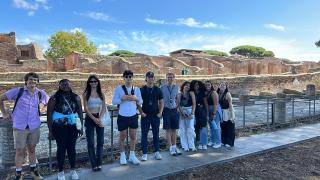 A group of college students standing in front of Roman ruins in Ostia Antica, Italy