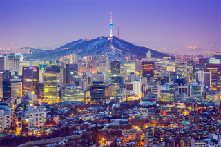 A view of Seoul, South Korea skyline and mountains beyond, at sunset
