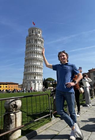 A student poses next to the Leaning Tower of Pisa